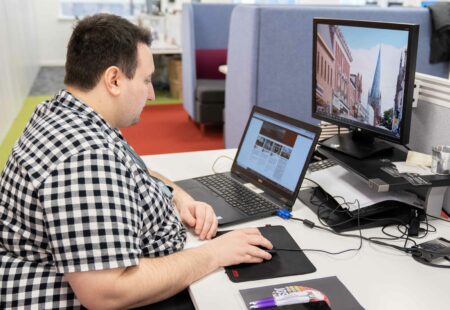 A male sat at a desk with a laptop