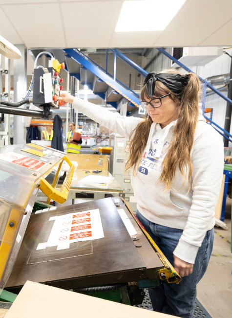 Female team member creating labels in the factory at MTM Products, Chesterfield