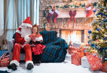 Santa sitting on a sofa with a little girl