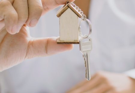 Man holding keyring with house model