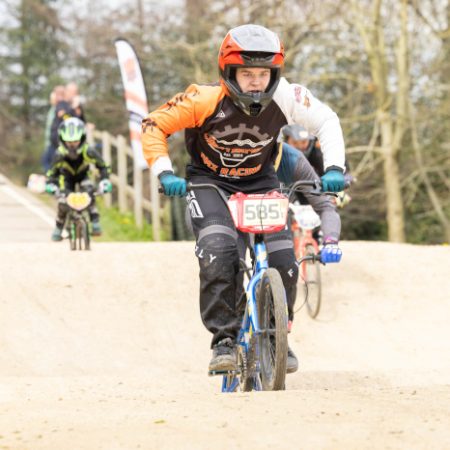 Young rider on bmx, other riders in background