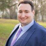 Josh Marsh in suit, grass and trees behind