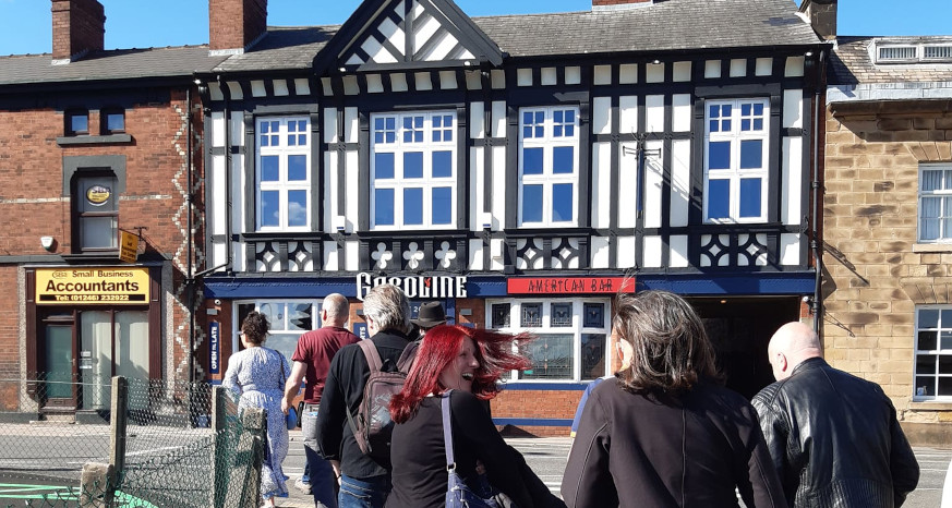 Group of people walking towards a tudor style pub