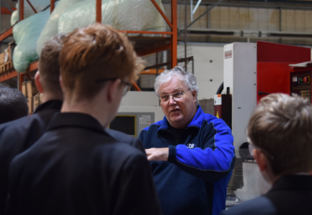 Man talking to a group of students in a warehouse