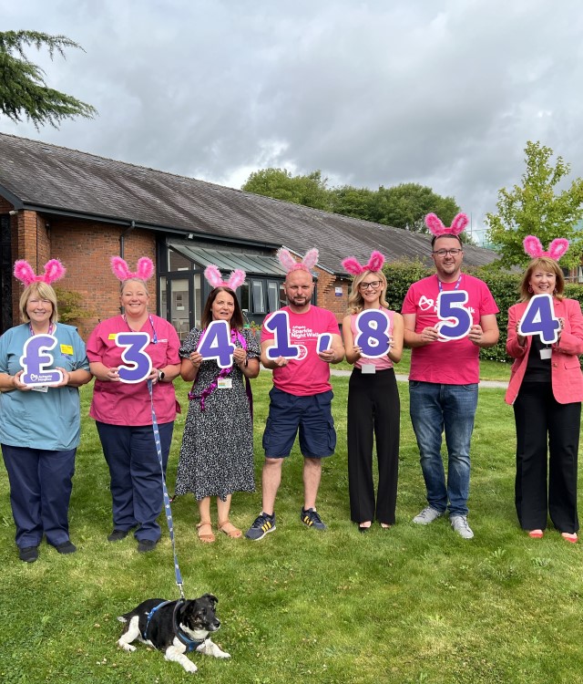 Group of people in pink clothes and bunny ears holding up numbers to signify Ashgate's sparkle walk fundraising total