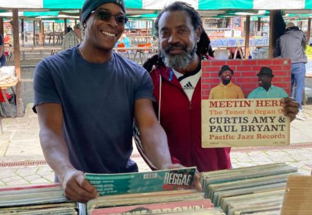 Stallholders at Chesterfield Record Fair holding up a vinyl record