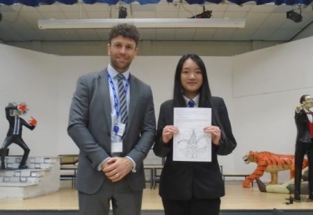 Teacher and pupil holding up artistic design