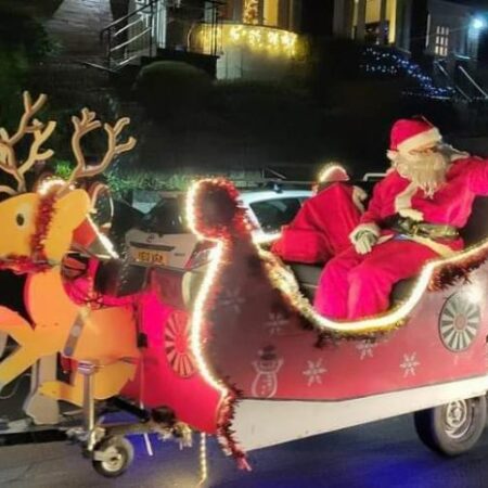 Santa on his sleigh waving to visitors on a street in Chesterfield