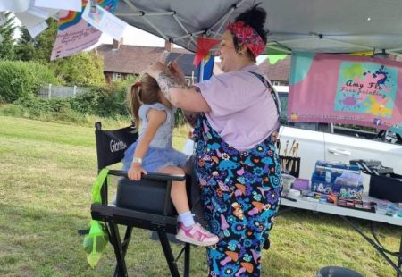 Child having face painted at community event