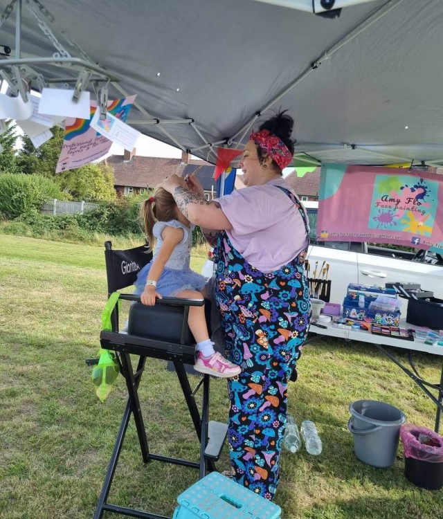 Child having face painted at community event