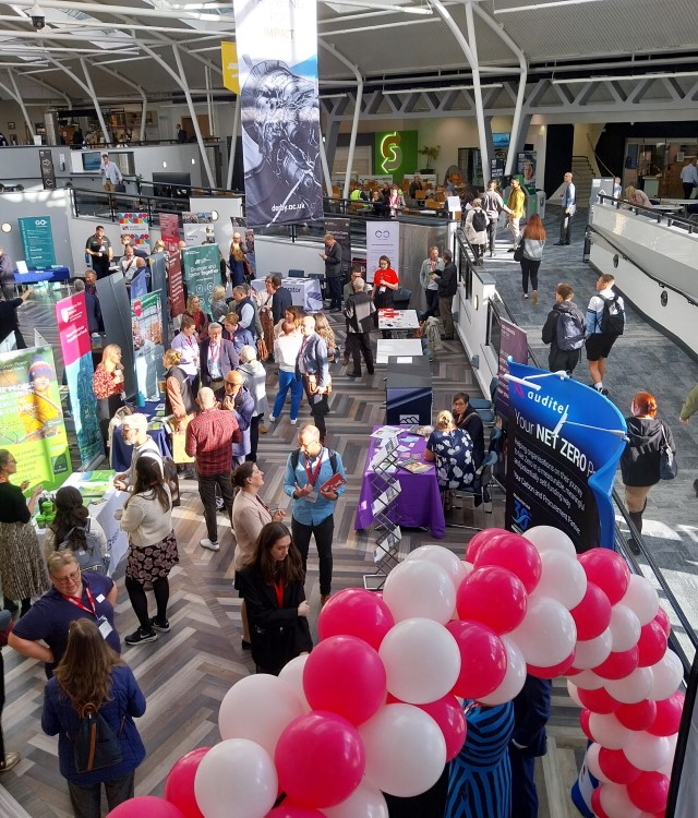 Busy University atrium with exhibitors displaying sustainability initiatives