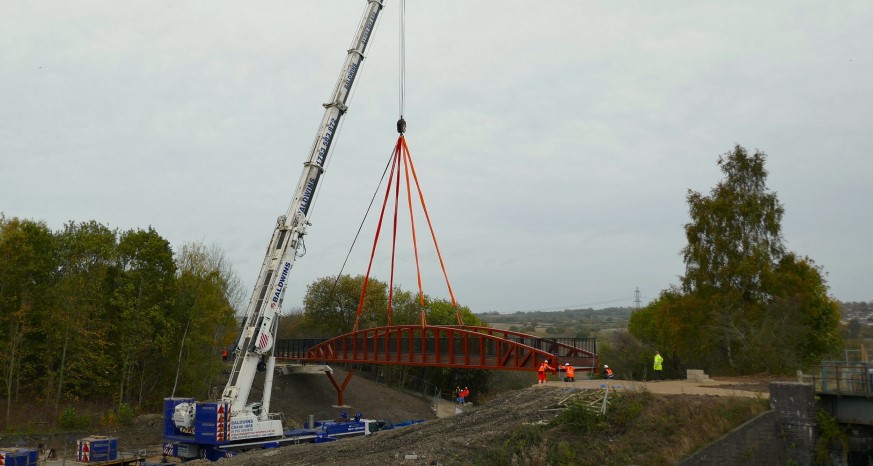 Crane lowers bridge onto bank