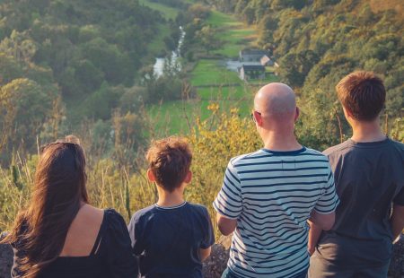 Woman, man and two boys standing looking at views of the countryside