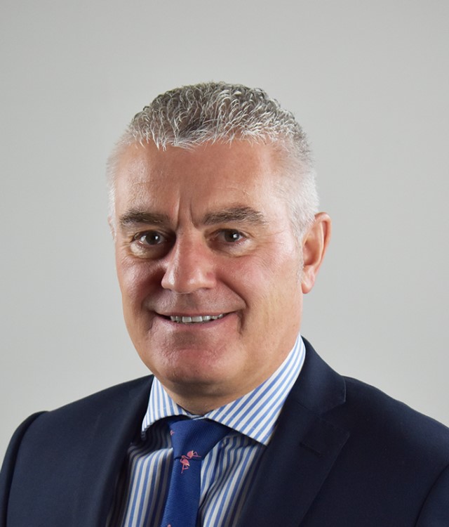 Man in suit smiles at camera