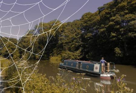 Canal boat on the water with a cobweb graphic in the top left corner