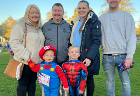 Family taking part in charity walk with children wearing superhero costumes