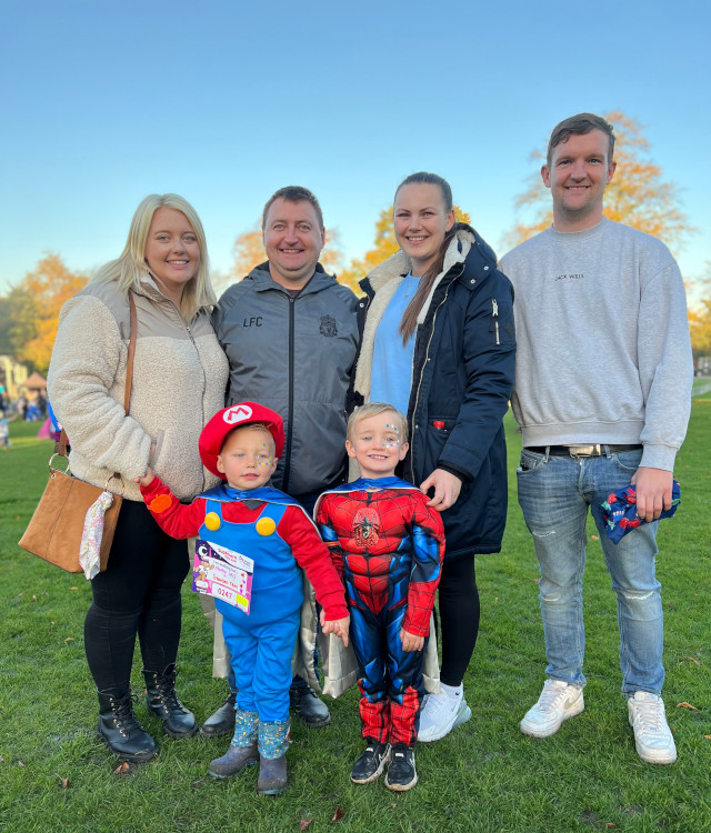 Family taking part in charity walk with children wearing superhero costumes