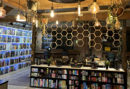 Interior of board game cafe with ambient lighting and shelves with game boxes neatly arranged