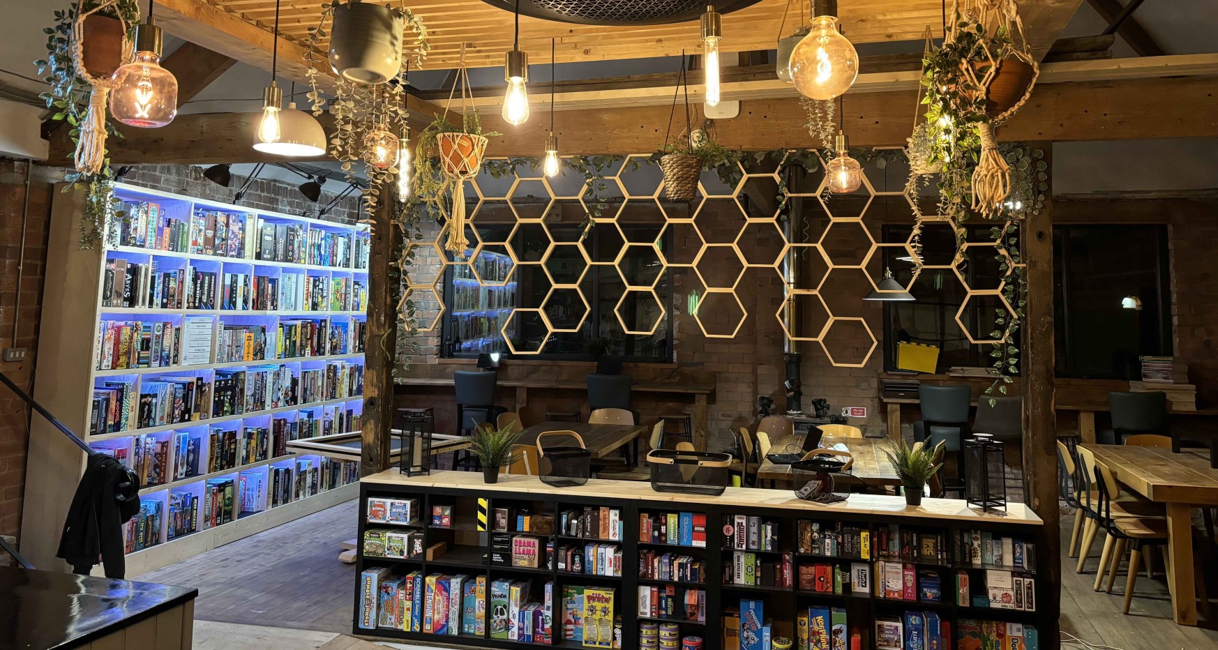 Interior of board game cafe with ambient lighting and shelves with game boxes neatly arranged