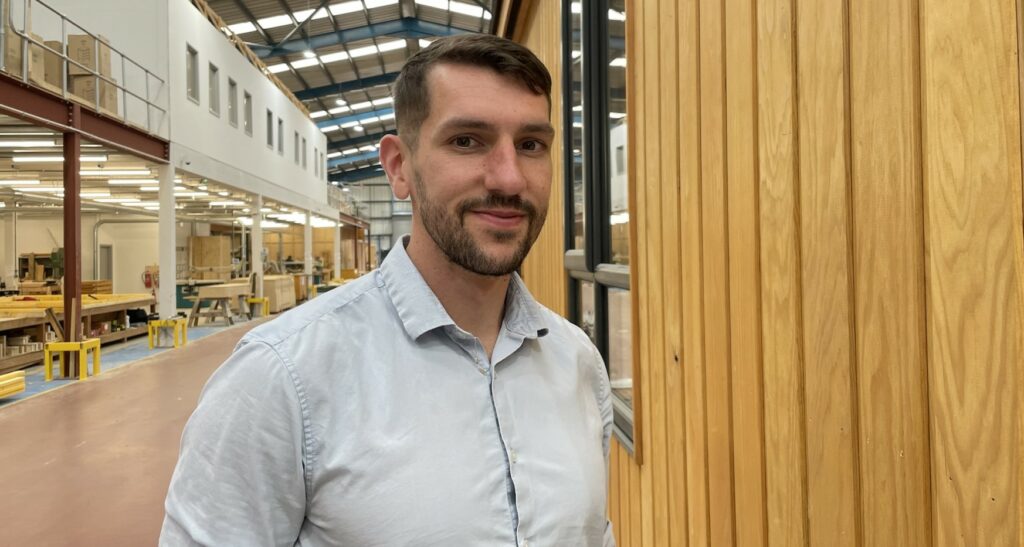 Man earing buttoned shirt in large workshop