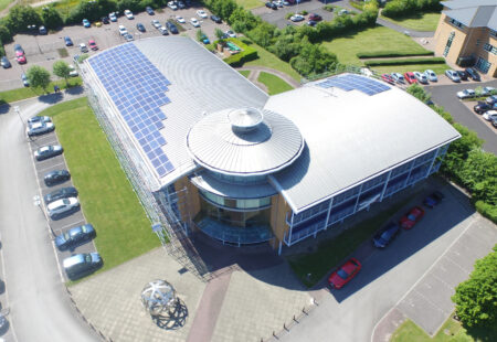 Solar panels on roof of modern office building - image taken from the air