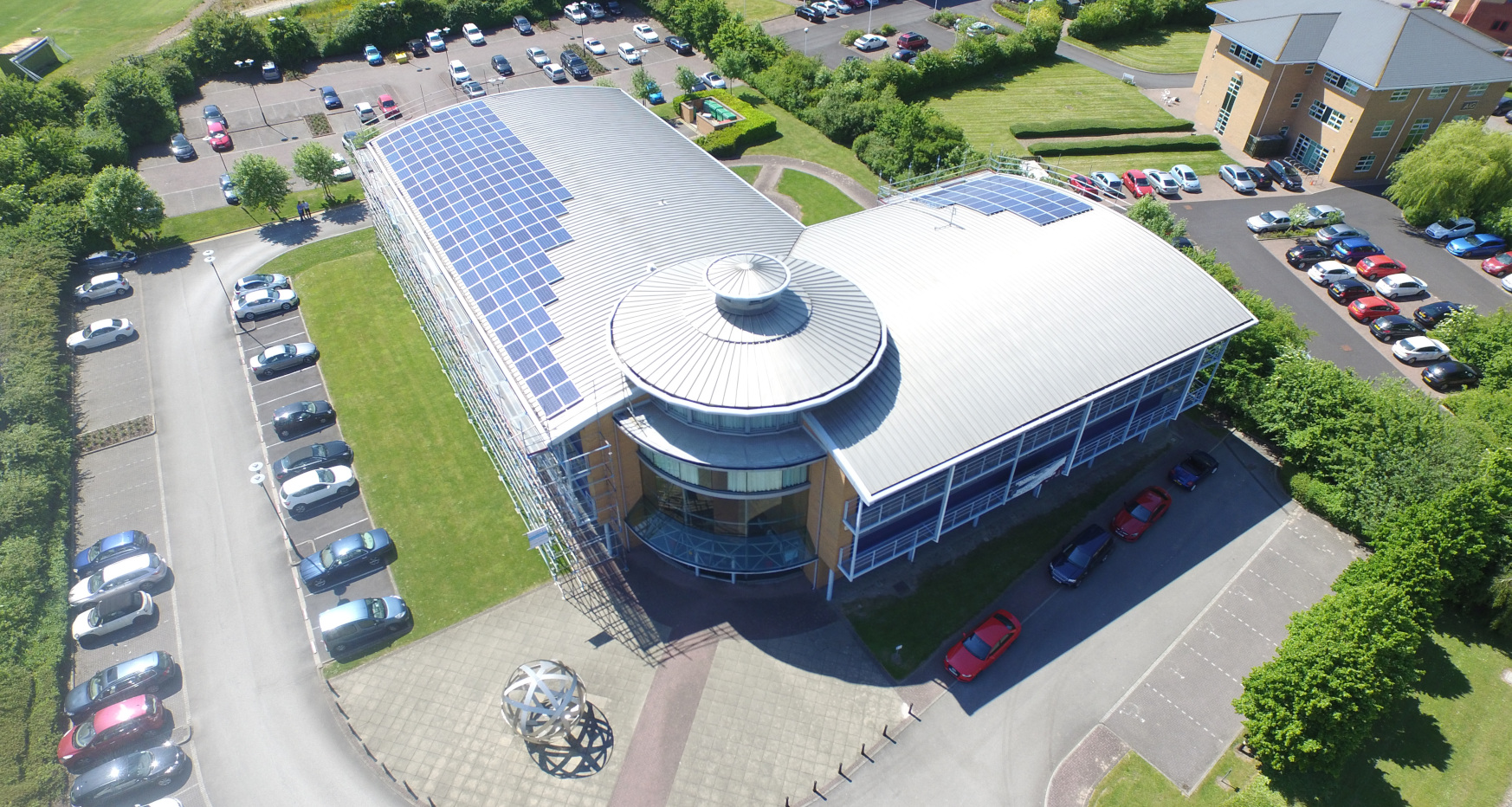 Solar panels on roof of modern office building - image taken from the air