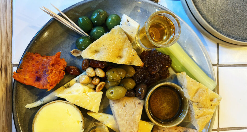 Plate of meditteranian food including bread, olives and cheeses